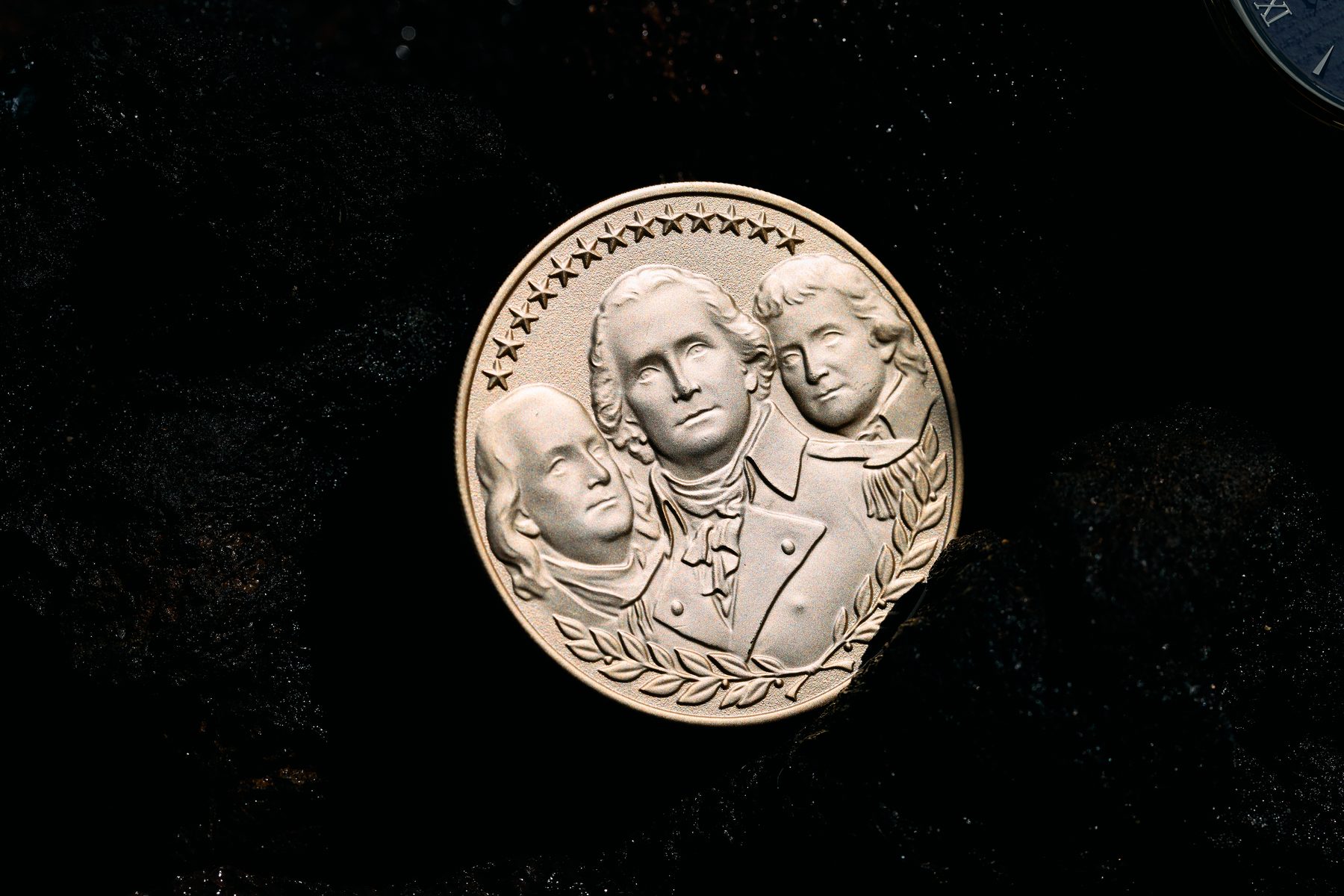 The We The People medallion on wet volcanic rock